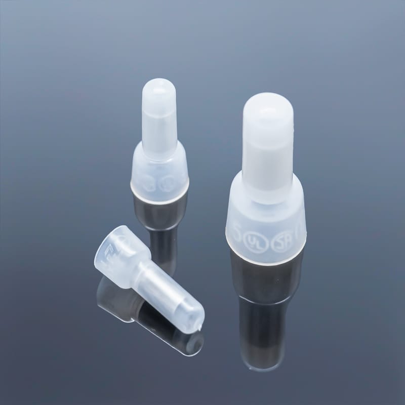Three different sizes of nylon insulated close end wire connectors on dark reflective background, small medium large comparison